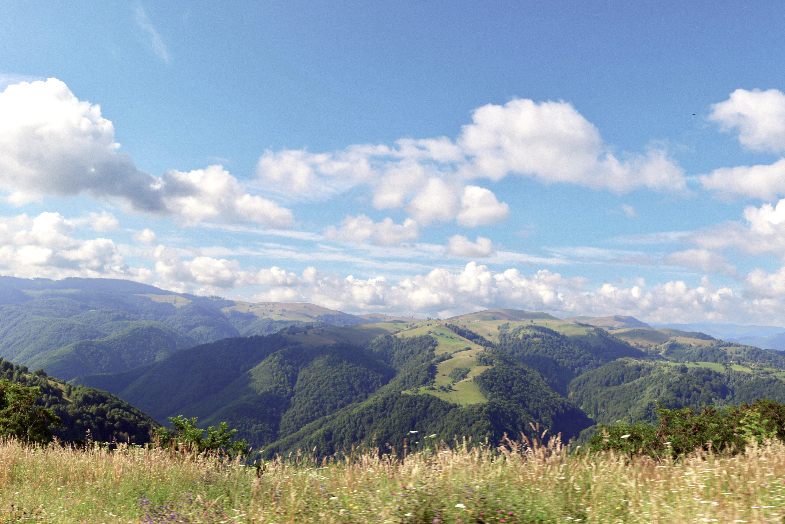 montanhas verdes sob o céu azul durante o dia